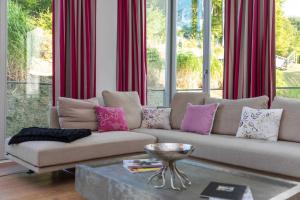 ein Wohnzimmer mit einem Sofa mit rosa und lila Kissen in der Unterkunft Villa Theres Dolphin in Ostseebad Sellin + 18 Fotos