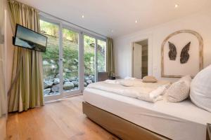 een slaapkamer met een groot bed en een groot raam bij Villa Theres Dolphin in Ostseebad Sellin