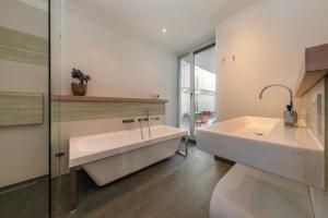 een badkamer met een bad, een wastafel en een toilet bij Villa Theres Dolphin in Ostseebad Sellin
