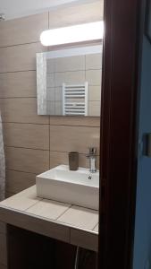 a bathroom with a white sink and a mirror at Kerkini Houses in Kerkíni