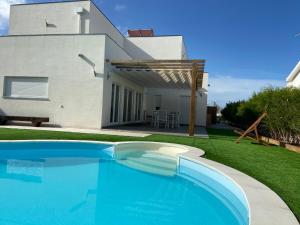 a swimming pool in front of a house at FamilyHost Charm Porto Covo in Porto Covo