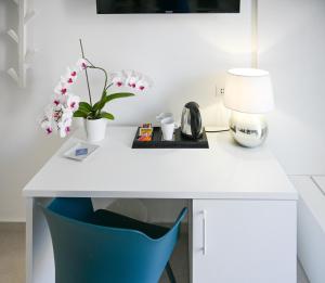 a white desk with a blue chair and a lamp at L'Ancora B&B in Milazzo