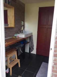 a kitchen with a sink and a red door at Iloons yurt in Hollandscheveld