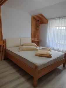 a large bed in a bedroom with a window at Motel Mesterul Manole in Curtea de Argeş