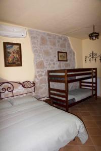 1 dormitorio con 2 camas y pared de piedra en Casale san Pietro, en Otricoli