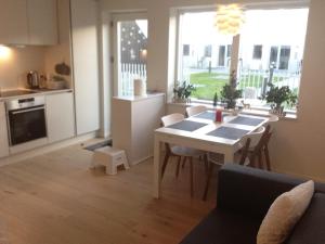 Ana's Bed & Kitchen في كوبنهاغن: مطبخ وغرفة معيشة مع طاولة وكراسي
