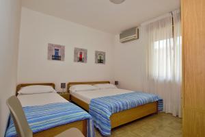 1 Schlafzimmer mit 2 Betten und einem Fenster in der Unterkunft Residenza Canova in Lignano Sabbiadoro