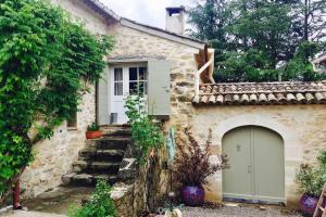a stone house with a gate and a garage at GITE COCOTTE LUBERON, FORCALQUIER in Pierrerue