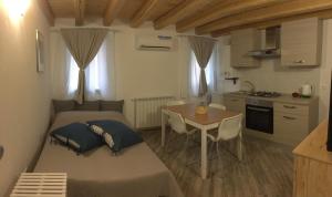 um quarto com duas camas e uma mesa e uma cozinha em South Lagoon Apartments 1 em Chioggia