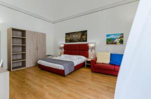 パレルモにあるBelmonte102 Esclusive Suitesのベッドルーム(ベッド1台、ソファ付)
