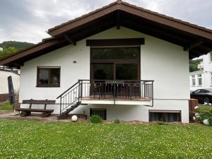 ein weißes Haus mit einem Balkon und einem Rasenhof in der Unterkunft Casa Salinum in Bad Kreuznach