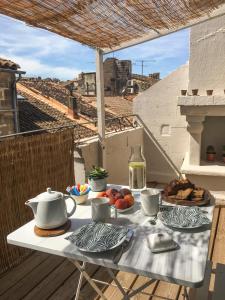 una mesa con comida y té en el balcón en Arles sous les toits - Terrasse proche des arènes, en Arles