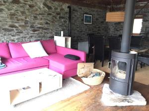 a living room with a pink couch and a fireplace at CABAÑA VENTO NORTE in Vilamós
