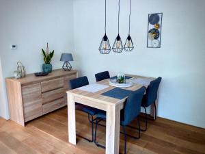 a dining room with a table and blue chairs at De Drie Beuken in 't Harde