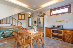a kitchen with a wooden table and chairs at ChiPa Homestay in Danang