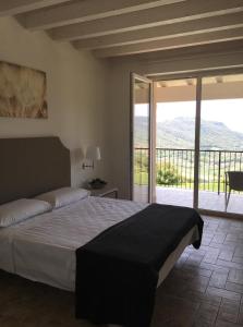 1 dormitorio con 1 cama grande y balcón en BellaVista Relax - Adults Only, en Costermano