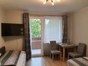 a room with two beds and a table and a window at Pokoje Gościnne in Krakow