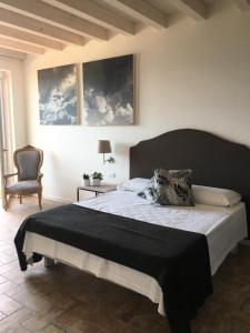 1 dormitorio con 1 cama grande y 1 silla en BellaVista Relax - Adults Only, en Costermano