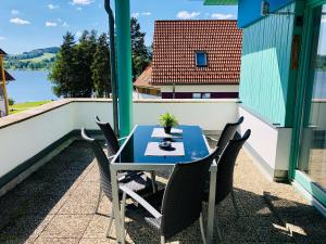 a table and chairs on a balcony with a view of the water at Apartmán Adam in Lipno nad Vltavou