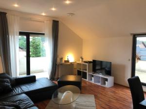 uma sala de estar com um sofá e uma televisão em Ferienwohnung Katja em Bad Lippspringe