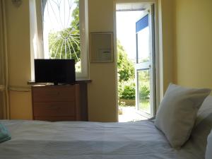 sypialnia z łóżkiem, telewizorem i oknem w obiekcie Alek-Gdynia Realizujemy bon turystyczny w mieście Gdynia