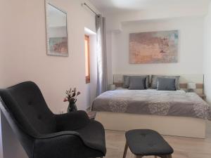 een slaapkamer met een bed en een stoel bij Old Town Studio in Novigrad Istria