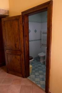 baño con aseo y puerta de madera en Casale san Pietro, en Otricoli