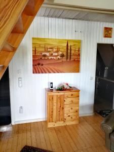 Zimmer mit einem Wandgemälde und einem Holzschrank in der Unterkunft Ferienhaus Mauer Krombachtalsperre, exclusive Nebenkosten Strom in Driedorf