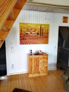 a room with a painting on the wall and a wooden cabinet at Ferienhaus Mauer Krombachtalsperre, exclusive Nebenkosten Strom in Driedorf