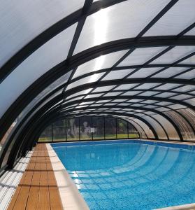 a large swimming pool with an overhead tunnel at Villa Maniszewo in Serbów
