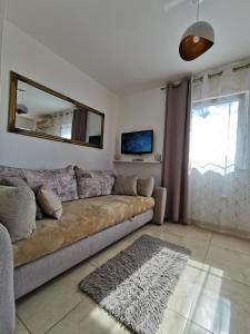 uma sala de estar com um sofá e um espelho em Apartments Lea with pool em Malinska