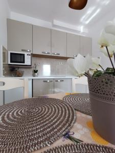 a kitchen with white cabinets and a vase with flowers at Apartments Lea with pool in Malinska