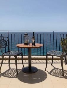 stół i 2 krzesła na balkonie z widokiem na ocean w obiekcie Soffio Dal Mare w mieście Letojanni