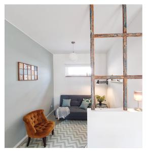 ElbQuartier Apartments Magdeburg 'Die Stadtoase' في ماغدبورغ: غرفة معيشة مع أريكة وكرسي