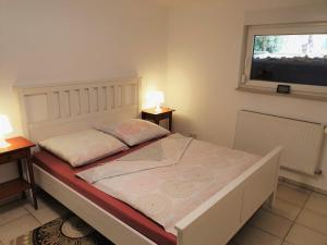 a bed in a room with two tables and a window at Moderne Einliegerwohnung AMARA - Friedrichshafen am Bodensee in Friedrichshafen