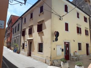 een geel gebouw met rode deuren op een straat bij Old Town Studio in Novigrad Istria