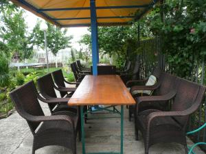 a wooden table and chairs under an umbrella at Dimitrovi Guest House in Aheloy