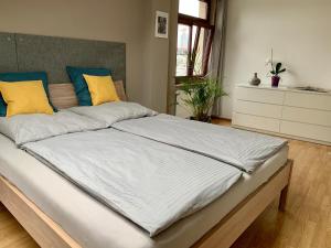 a bedroom with a large bed with yellow and blue pillows at Charmante Dachgeschoss Wohnung in Leipzig
