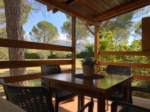 a table and chairs on the porch of a cabin at Camping Oliana in Oliana