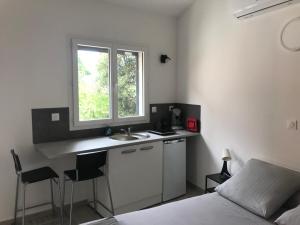 a bedroom with a sink and a bed and a window at Beach House in Fos-sur-Mer