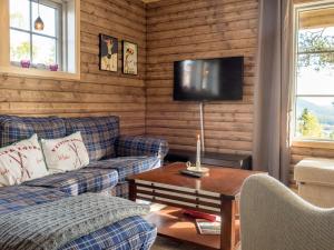 a living room with a couch and a table and a tv at Alpstigen 8B in Järvsö