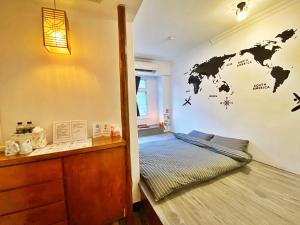瑞芳區的住宿－九份金瓜石食字客棧，一间设有一张床铺的客房,墙上挂着世界地图