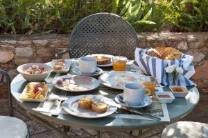 a table with plates of breakfast food on it at Kalamitsi Hotel in Kardamyli