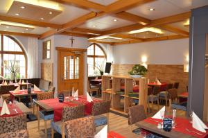 a dining room with tables and chairs and windows at Hotel Sonne - Das kleine Altstadt Hotel in Rothenburg ob der Tauber