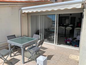 una mesa de cristal y sillas en un patio en MARINA LOVE, en Cap d'Agde