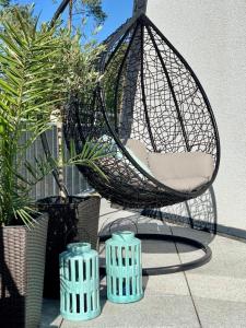 a hammock chair sitting on a patio with plants at Apartamenty Silence Baltic Indygo in Pobierowo