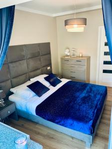 a bedroom with a large bed with a blue blanket at Apartamenty Silence Baltic Indygo in Pobierowo