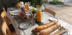 a table with a loaf of bread and bottles of orange juice at La petite maison in Saint-Georges-sur-Cher