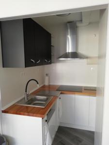 una cocina con armarios en blanco y negro y fregadero en Pitaya en Algarrobo-Costa