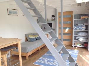 a room with a loft bed with a desk and a table at Gîte Bambou in Saint-Lunaire